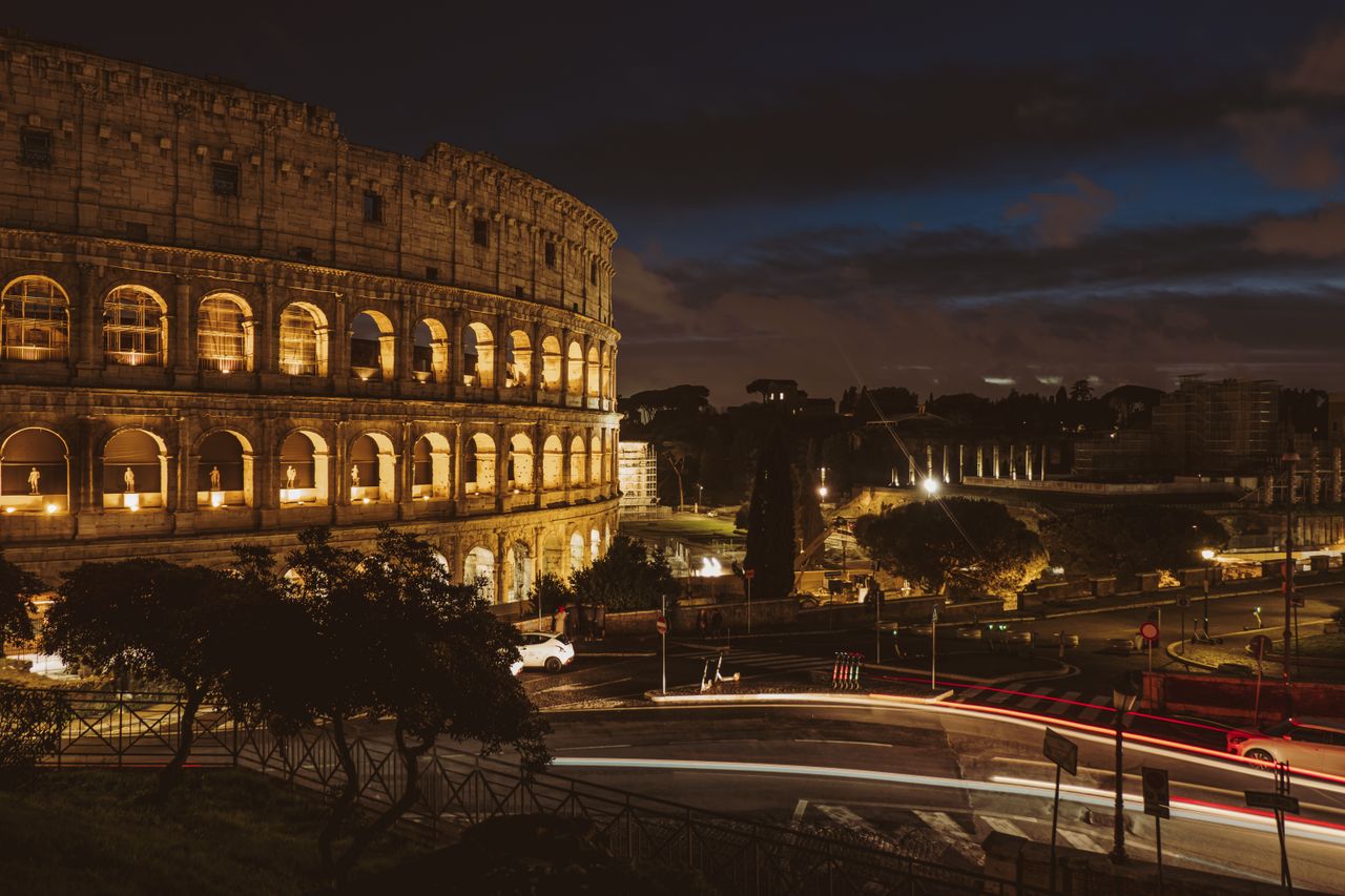 Stunning nighttime view of the illuminated Colosseum in Rome, capturing its historical grandeur.