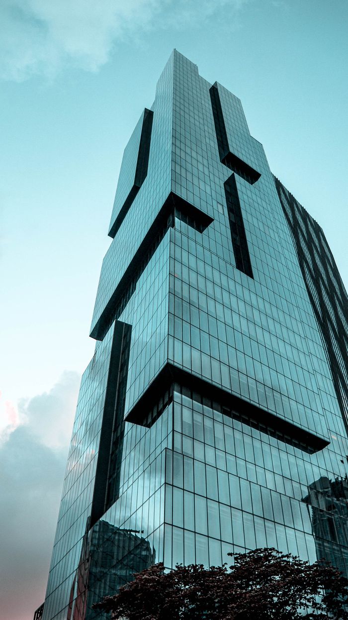 Mastering the First Impression: Your intriguing post title goes here Stunning modern skyscraper with glass panels under a clear blue sky, viewed from below.
